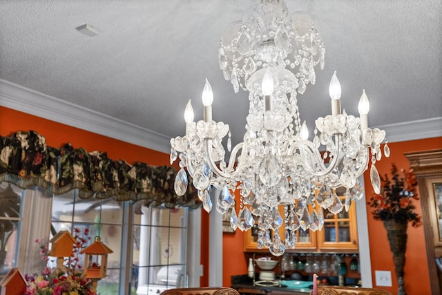 room details with ornamental molding, a textured ceiling, and a notable chandelier