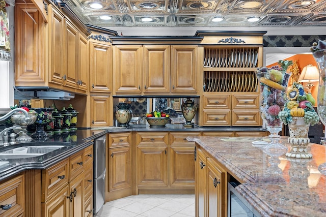 kitchen featuring light tile patterned flooring, stone countertops, and sink