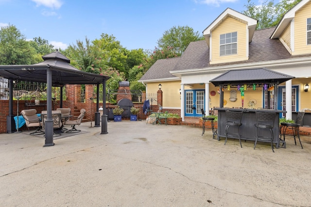 view of patio / terrace with a gazebo, fence, french doors, and outdoor dry bar