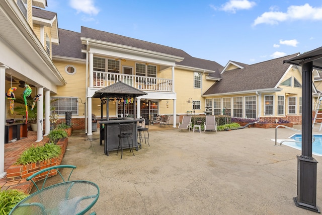 back of house featuring an outdoor bar and a patio area