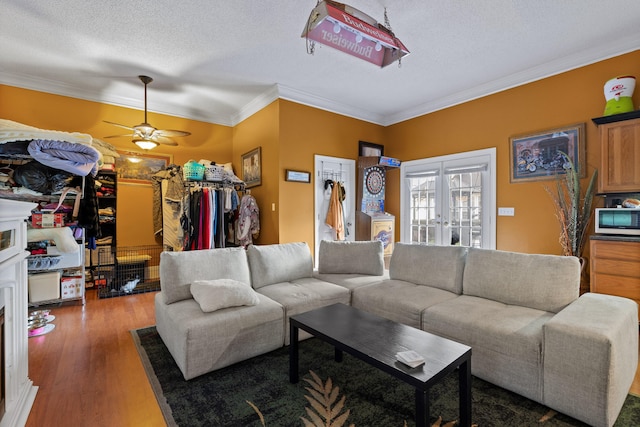 living room featuring crown molding, ceiling fan, dark hardwood / wood-style floors, a textured ceiling, and french doors