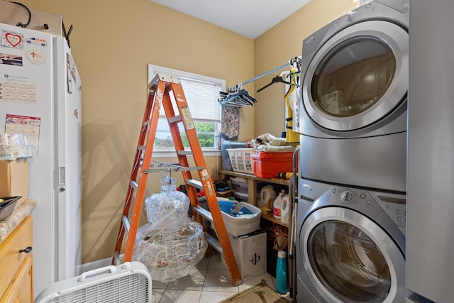 clothes washing area featuring laundry area, stacked washing maching and dryer, and tile patterned floors