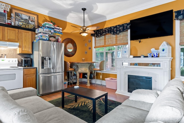 living room with hardwood / wood-style flooring, ornamental molding, and ceiling fan