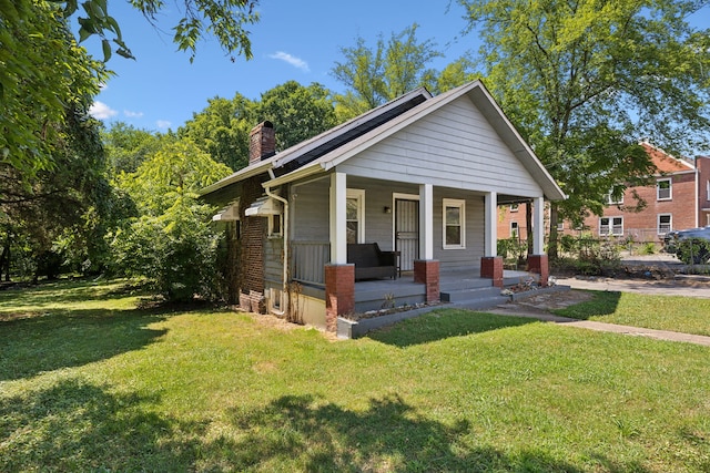 bungalow-style house with a front lawn and covered porch