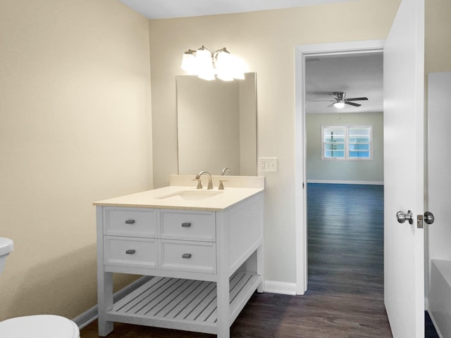 bathroom featuring ceiling fan, vanity, wood-type flooring, and toilet