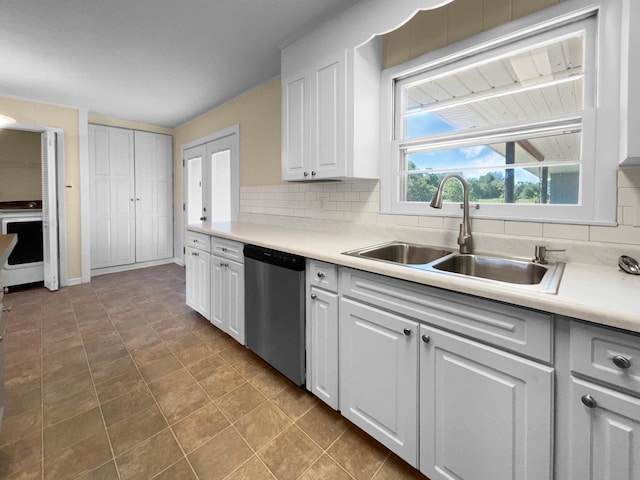 kitchen featuring decorative backsplash, tile patterned floors, stainless steel dishwasher, sink, and white cabinetry