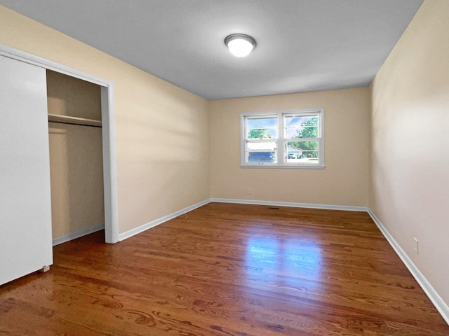 unfurnished bedroom featuring dark hardwood / wood-style floors and a closet