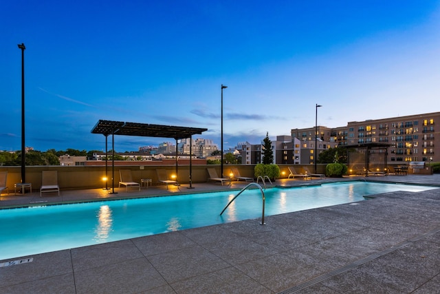 pool at dusk featuring a patio