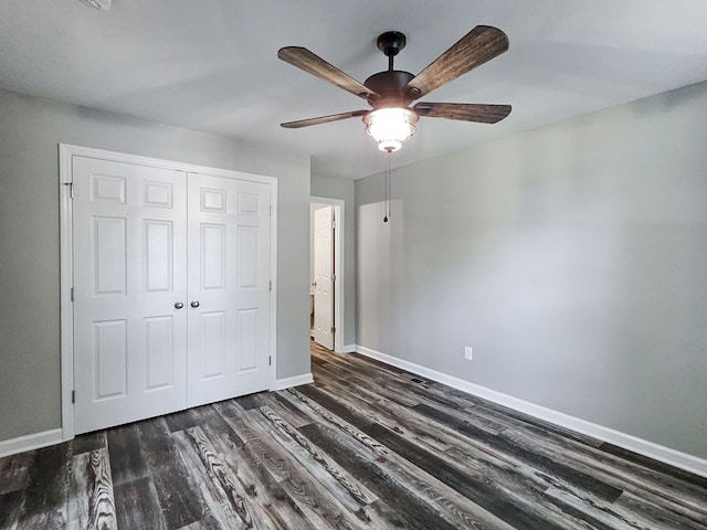 unfurnished bedroom featuring dark hardwood / wood-style floors, ceiling fan, and a closet