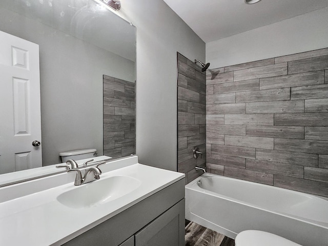 full bathroom with vanity, tiled shower / bath combo, toilet, and hardwood / wood-style flooring