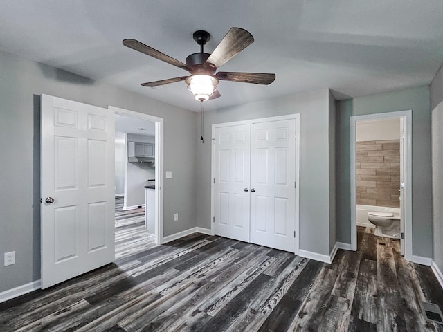 unfurnished bedroom with dark wood-type flooring, ceiling fan, and connected bathroom