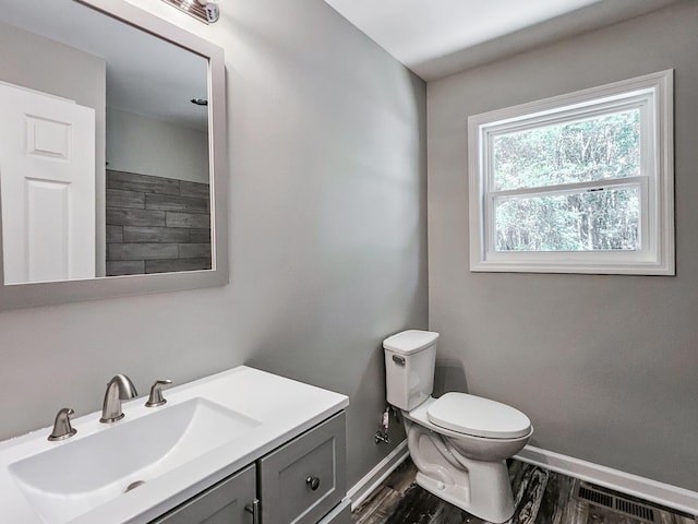 bathroom with vanity, toilet, and hardwood / wood-style floors