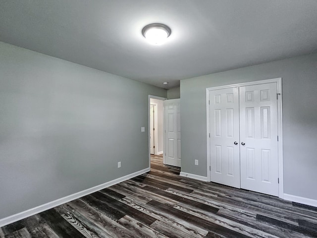 unfurnished bedroom featuring dark wood-type flooring and a closet