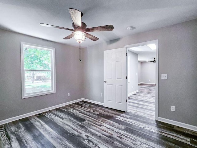 unfurnished room with ceiling fan and dark hardwood / wood-style flooring