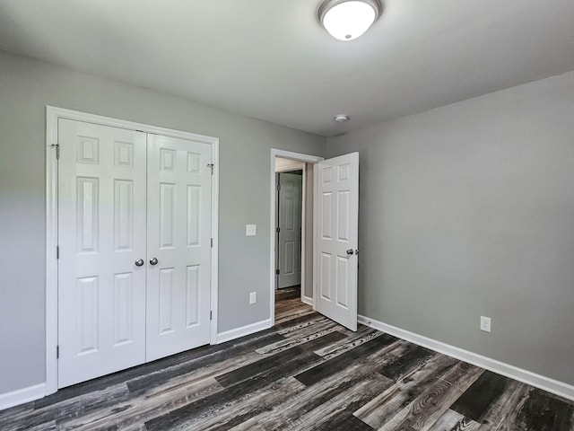 unfurnished bedroom featuring dark hardwood / wood-style floors and a closet