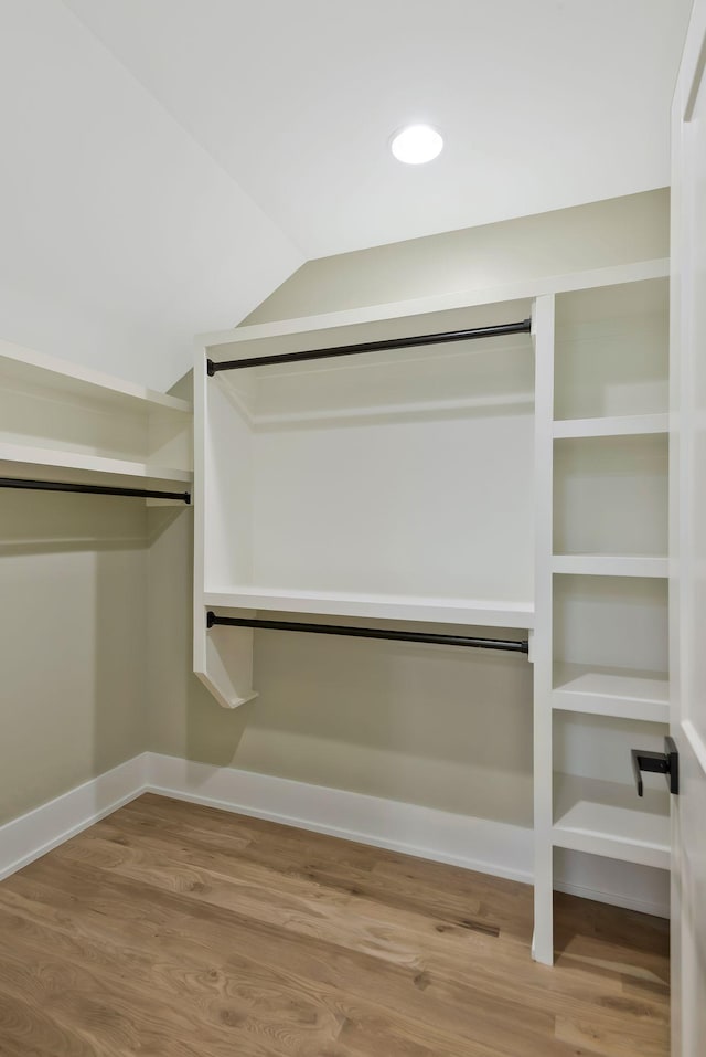 spacious closet featuring hardwood / wood-style floors and lofted ceiling