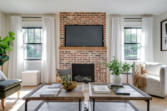 living room featuring light hardwood / wood-style flooring and a brick fireplace