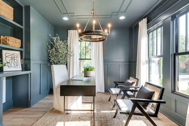 dining space with light hardwood / wood-style flooring and a chandelier