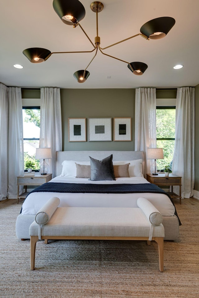 bedroom featuring a chandelier and multiple windows