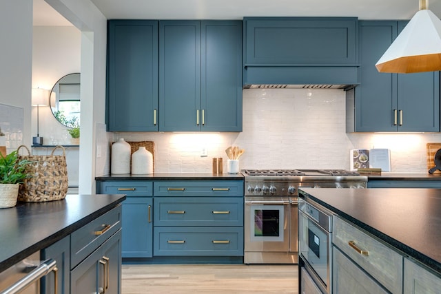 kitchen featuring double oven range, blue cabinetry, and tasteful backsplash