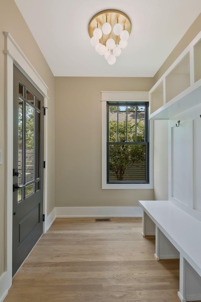 mudroom featuring a chandelier and light hardwood / wood-style floors