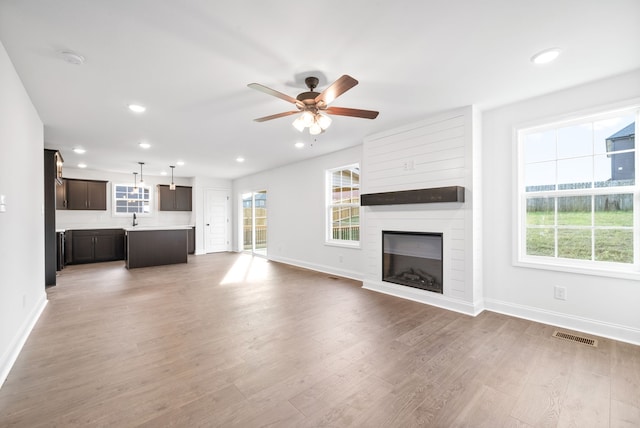 unfurnished living room featuring ceiling fan, a fireplace, and hardwood / wood-style floors