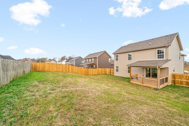 rear view of house featuring a yard and a wooden deck