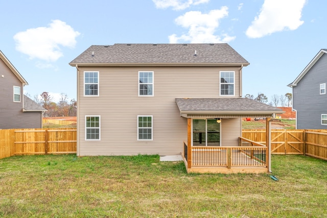 rear view of house with a wooden deck and a lawn