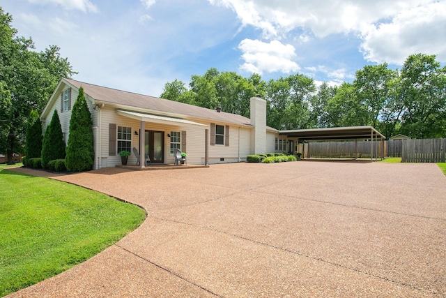 rear view of house featuring a carport and a yard