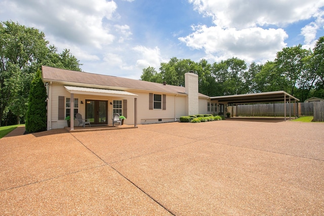 rear view of property with french doors and a carport