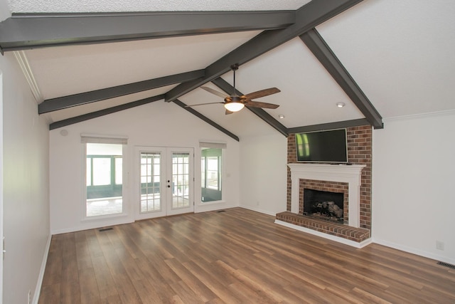 unfurnished living room with ceiling fan, a fireplace, dark hardwood / wood-style floors, lofted ceiling with beams, and french doors