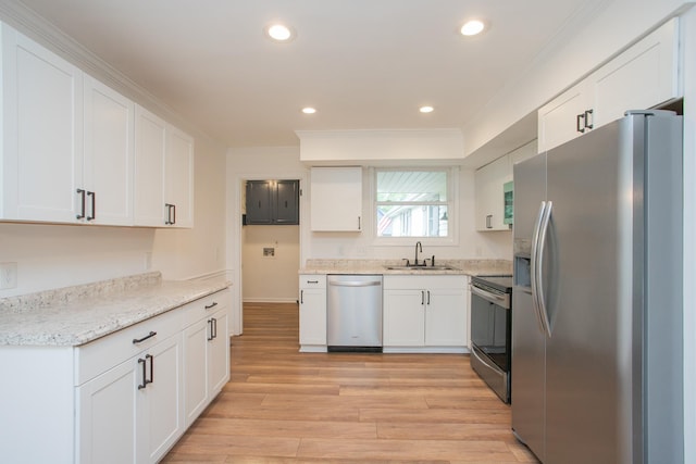 kitchen with sink, light wood-type flooring, appliances with stainless steel finishes, ornamental molding, and white cabinets