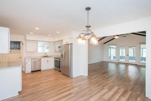 kitchen with appliances with stainless steel finishes, decorative light fixtures, ceiling fan with notable chandelier, white cabinets, and sink