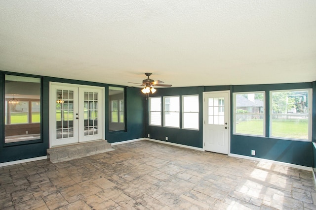 unfurnished sunroom with ceiling fan and french doors