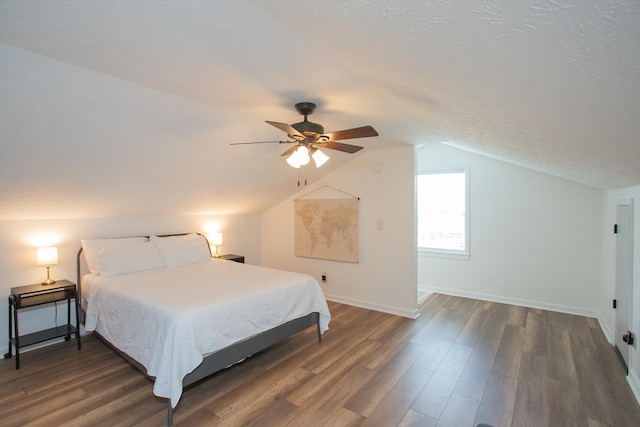 bedroom featuring ceiling fan, dark hardwood / wood-style floors, a textured ceiling, and lofted ceiling