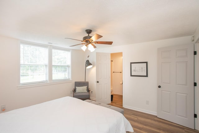 bedroom featuring ceiling fan, dark hardwood / wood-style floors, and ensuite bath