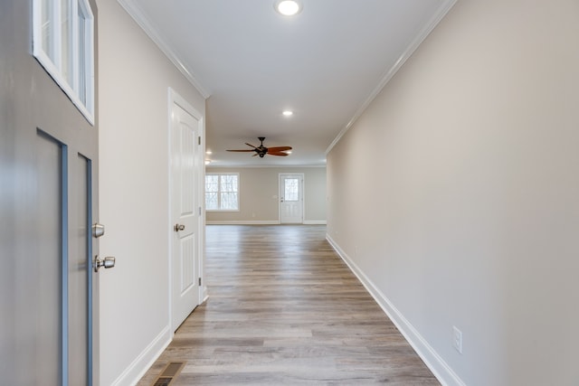 corridor featuring light hardwood / wood-style floors and crown molding