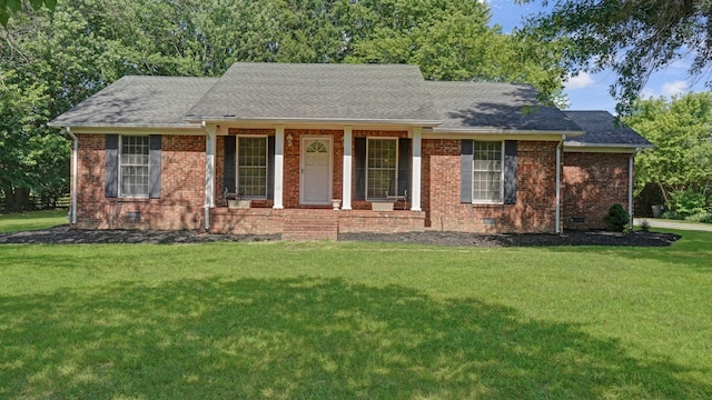 ranch-style home featuring covered porch and a front lawn