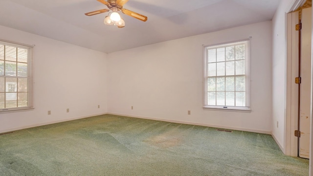 carpeted spare room featuring ceiling fan