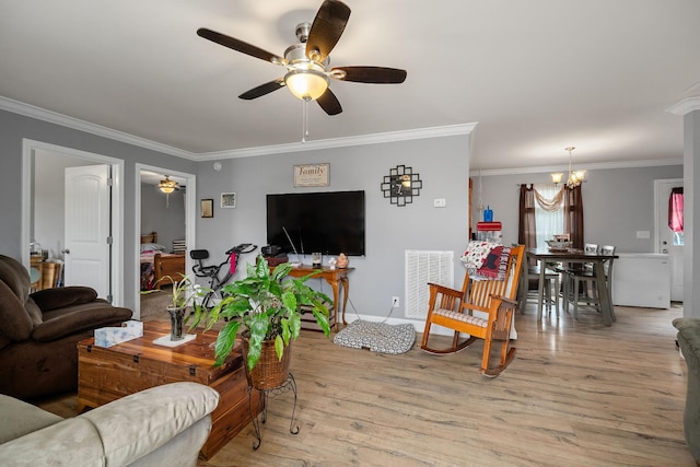 living room with ceiling fan with notable chandelier, light hardwood / wood-style floors, and ornamental molding