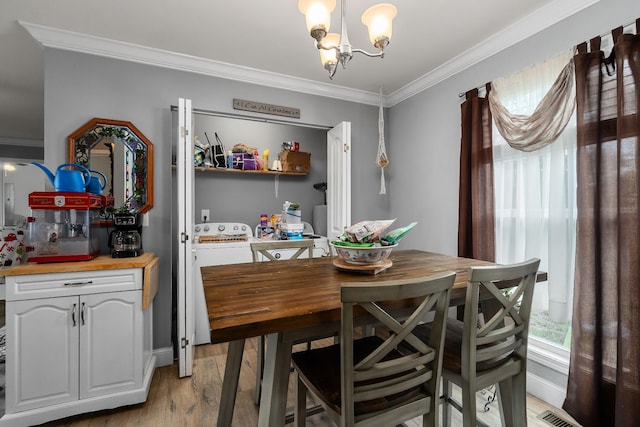 dining room featuring light hardwood / wood-style flooring, ornamental molding, and a notable chandelier