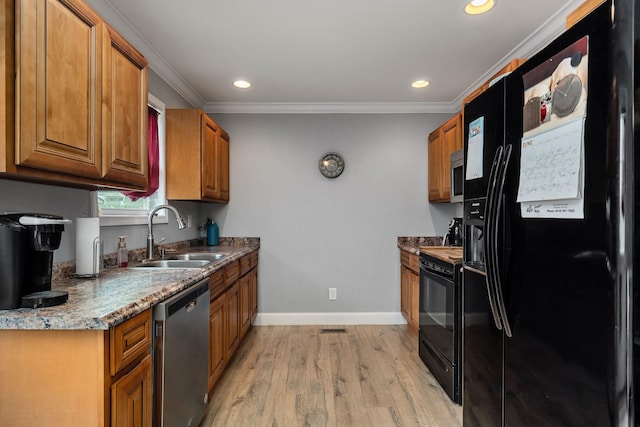 kitchen with sink, light hardwood / wood-style flooring, crown molding, dark stone counters, and black appliances