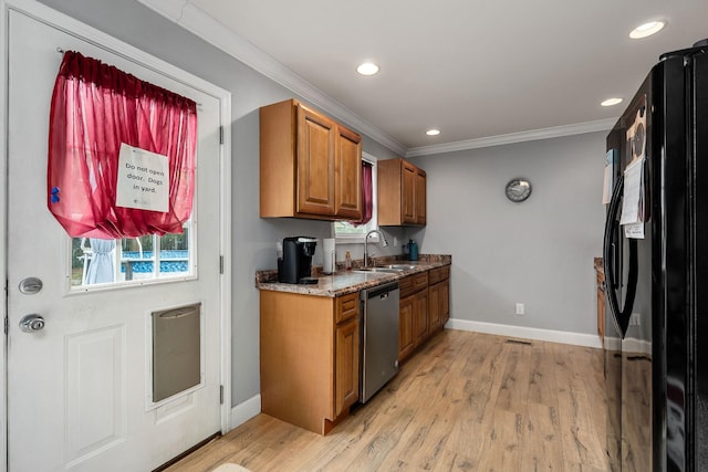 kitchen featuring black fridge, stainless steel dishwasher, ornamental molding, sink, and light hardwood / wood-style floors