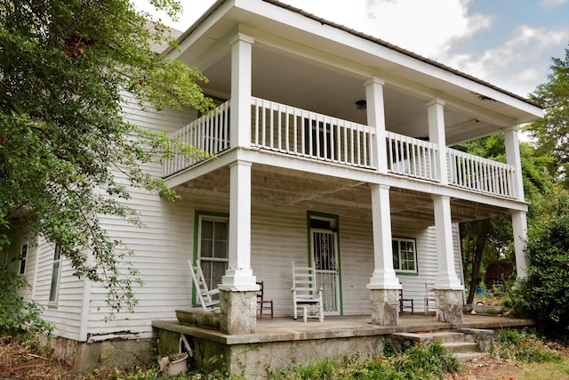 rear view of house featuring a porch