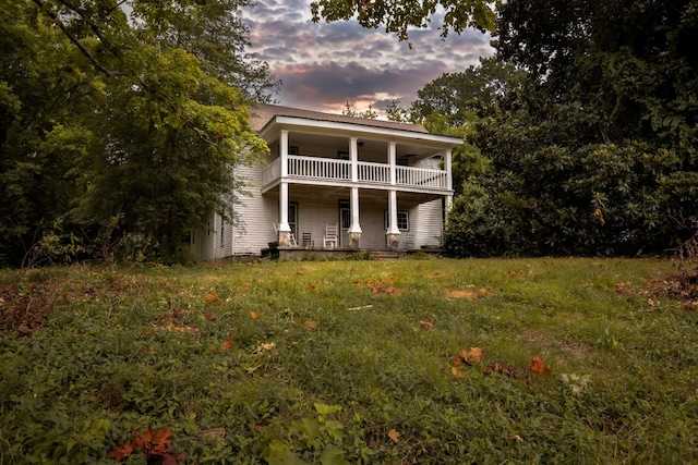 back house at dusk with a balcony