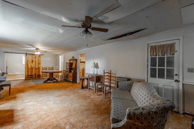 living room with ceiling fan and a barn door