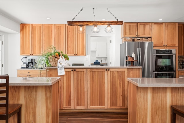 kitchen with dark hardwood / wood-style floors, a kitchen island, sink, and stainless steel appliances