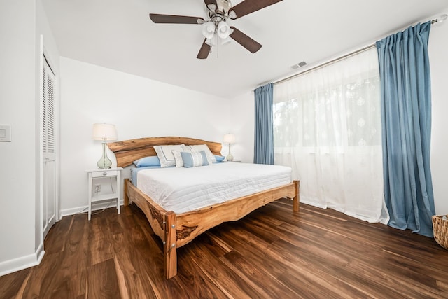 bedroom with ceiling fan, a closet, and dark wood-type flooring