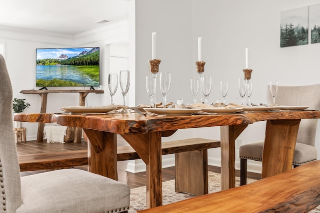 dining room with hardwood / wood-style flooring and crown molding