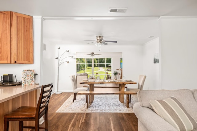 dining space featuring ceiling fan, dark hardwood / wood-style flooring, and ornamental molding